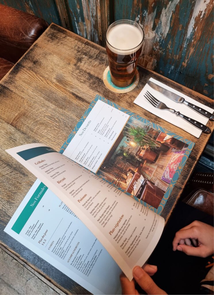 Menu ouvert du Café Marcel présentant les plats et desserts
